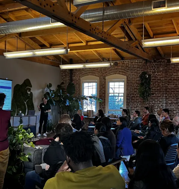 Audience listening to a speaker beside a presentation screen